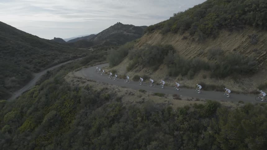 A group of cyclists riding bicycles up a mountain road