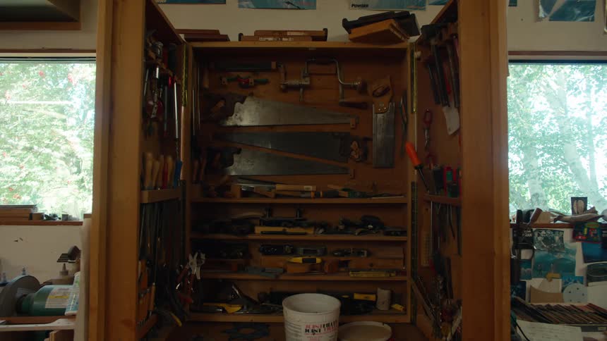 Various tools on a wooden shelf in an indoor space
