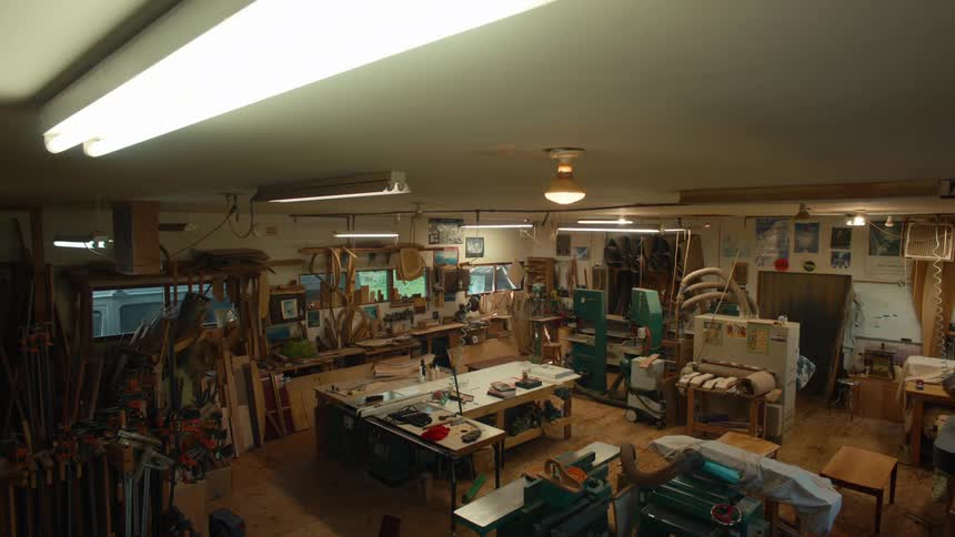 The fluorescent lights flickered on and off illuminating the cluttered workshop with a harsh white glow