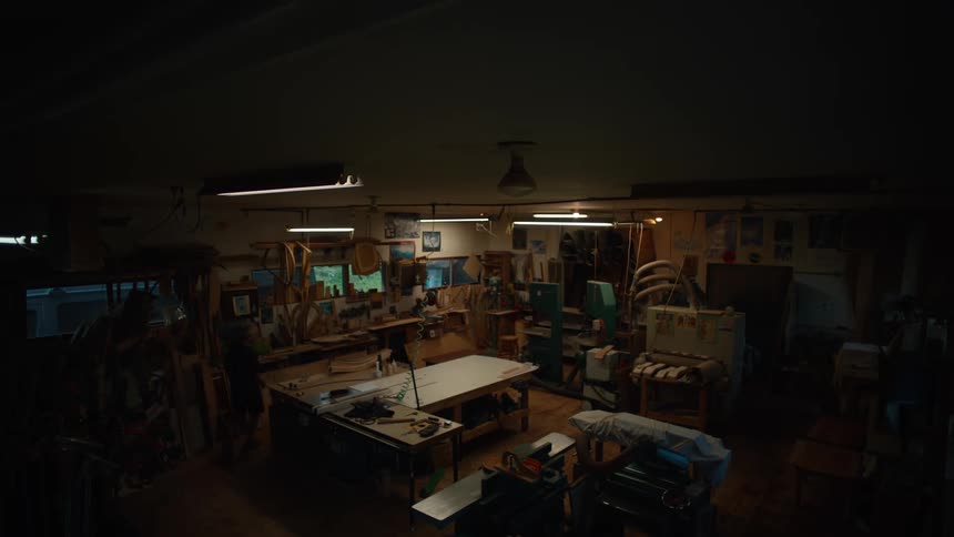 Man walking in an indoor workspace with tools