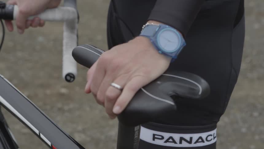 A bicyclist grips handlebars and the seat