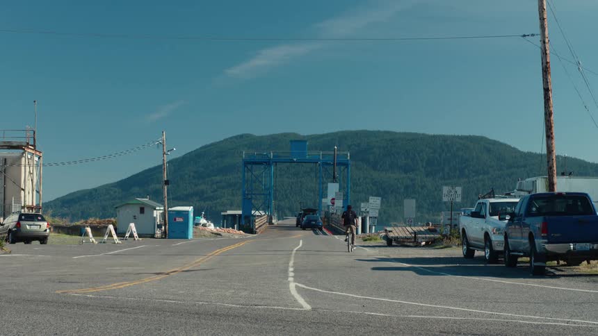 Man riding a bike towards a bridge