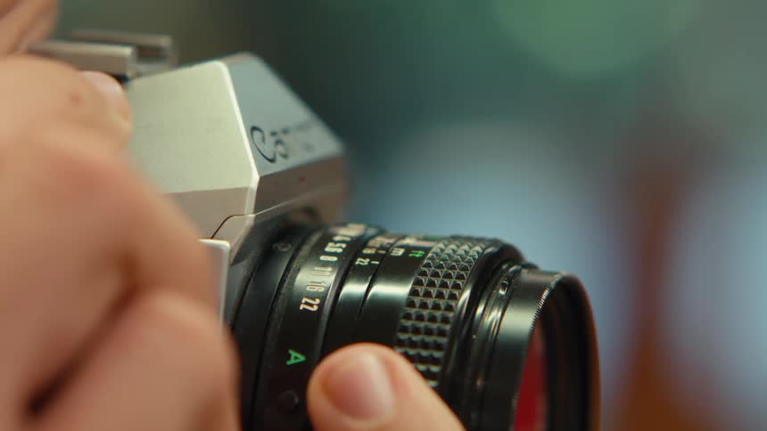A closeup shot of a vintage film camera being used in focus