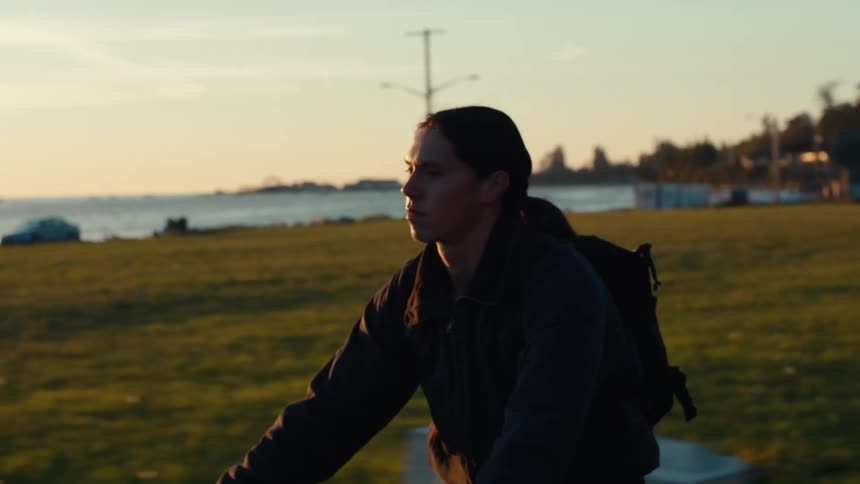 A man rides his bicycle past the lake