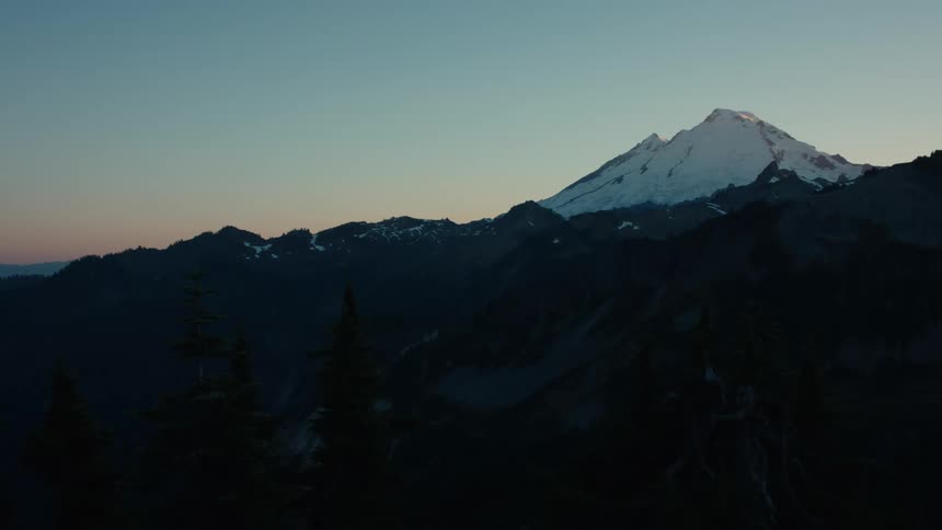 Landscape of a mountain valley with a snowy peak on the horizon in a morning