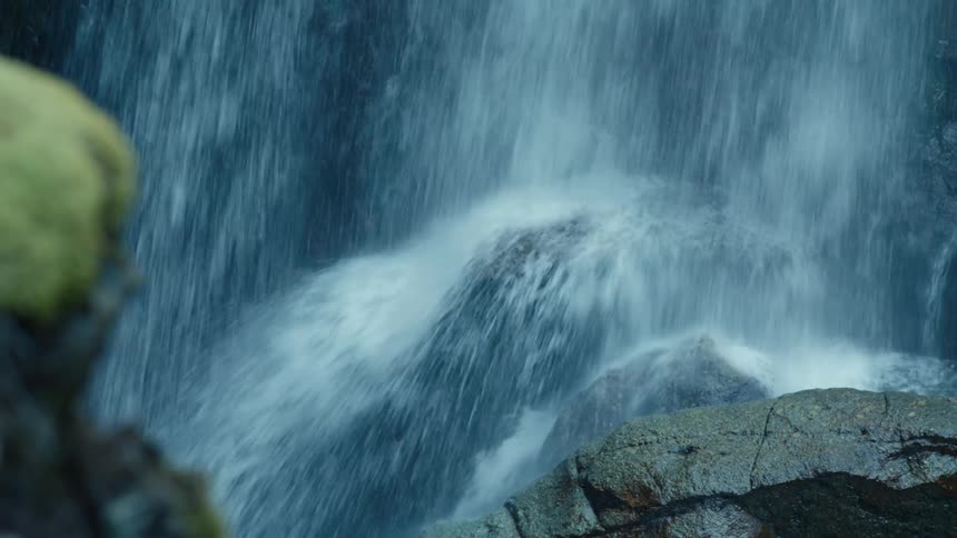 Water pounds onto boulders at the base of the waterfall