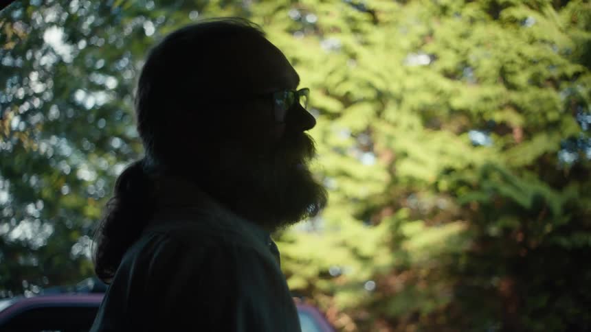 Side portrait of a man wearing glasses talking