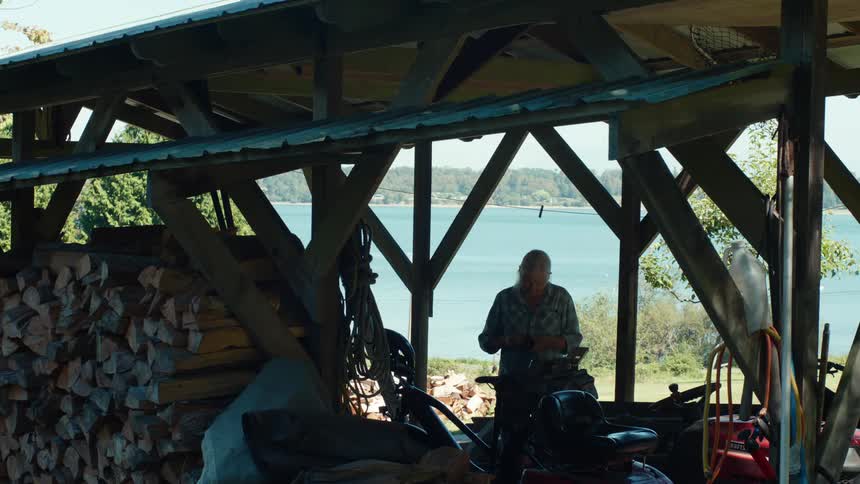 Woman on a ranch with firewood holding an object