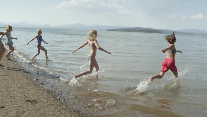 Young children run to the water playfully