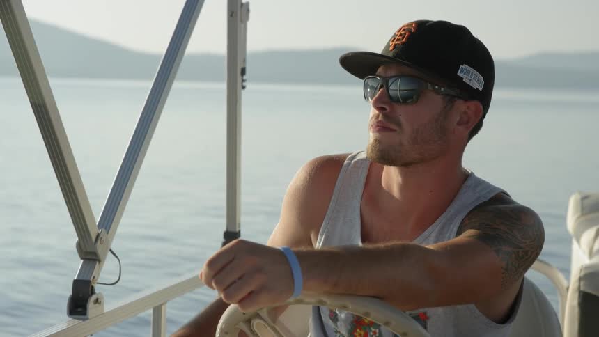 Man sitting on a boat in the water looks around