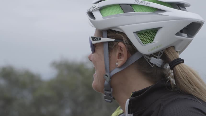 Woman wearing a helmet looks out at the trees