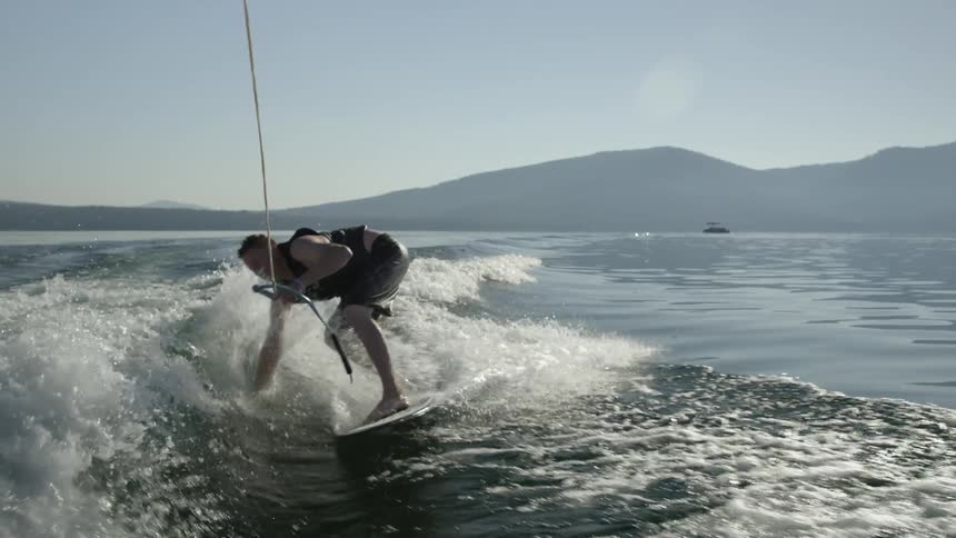 Man wake boarding feels the waves by his feet