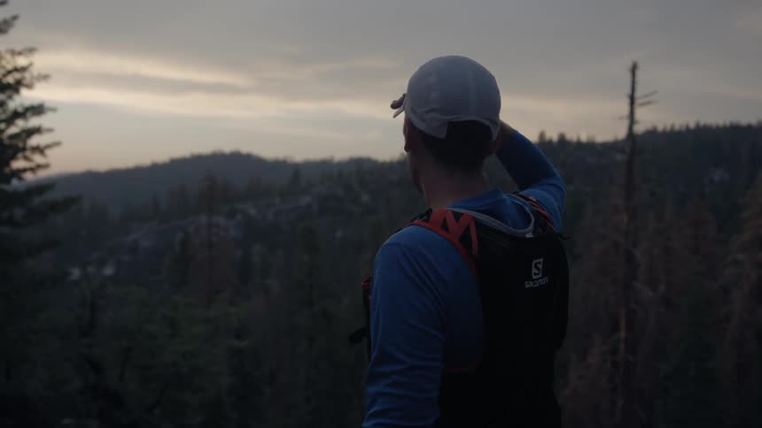 Man looks out at the trees during sunset