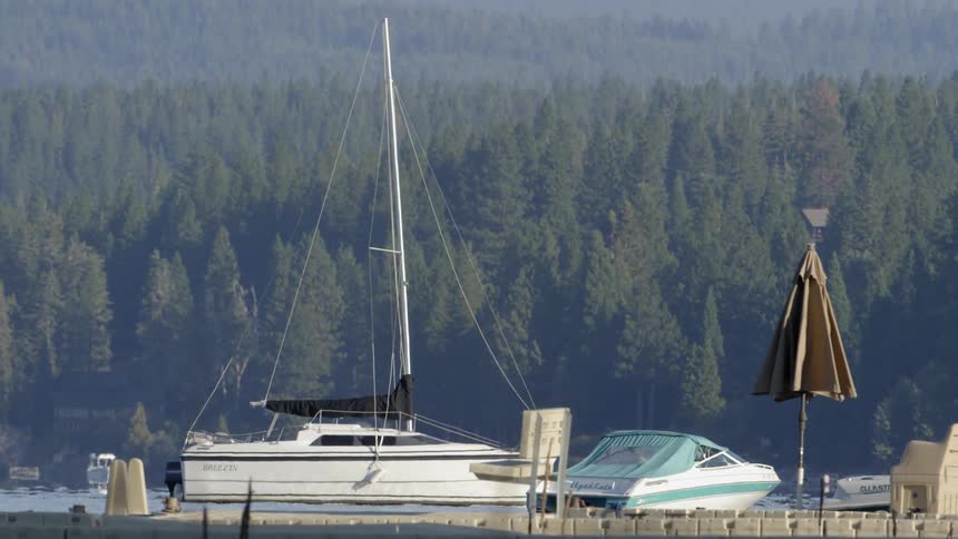A sailboat floating docked near another boat