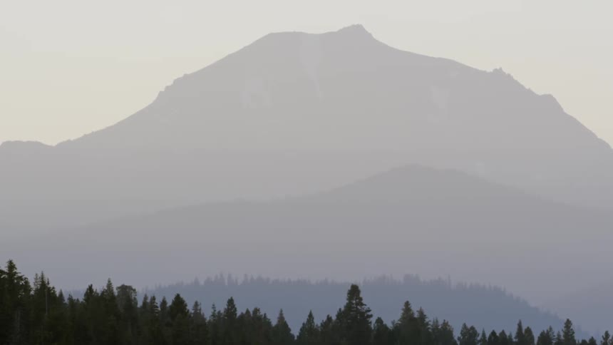 A view of a  large mountain view with trees below