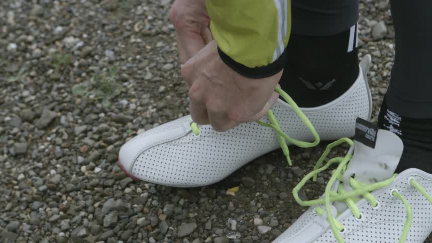 A person laces up their athletic shoes