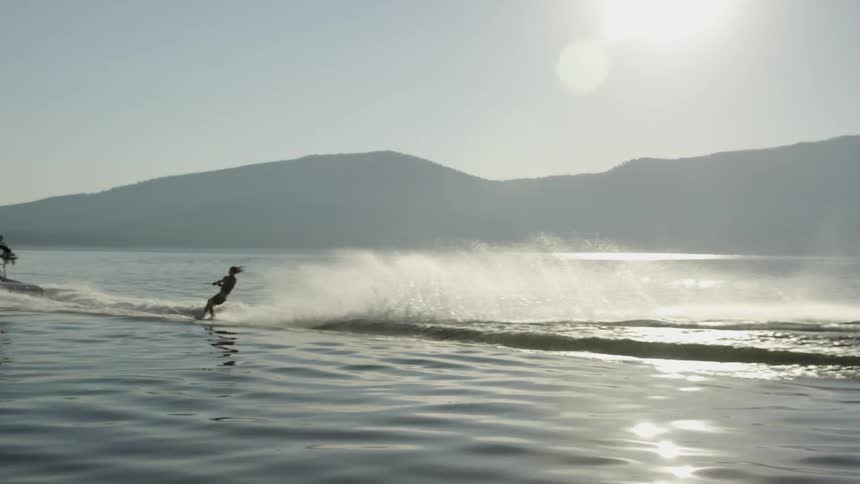 Person water skiing in a large lake on a sunny day