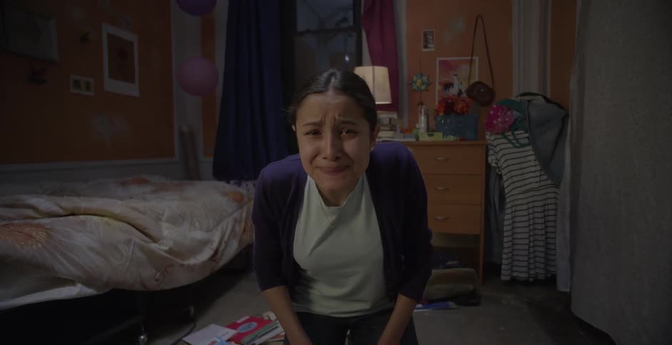 A girl cries in her bedroom