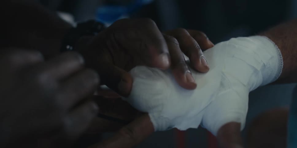 Hands bandaging another persons hand