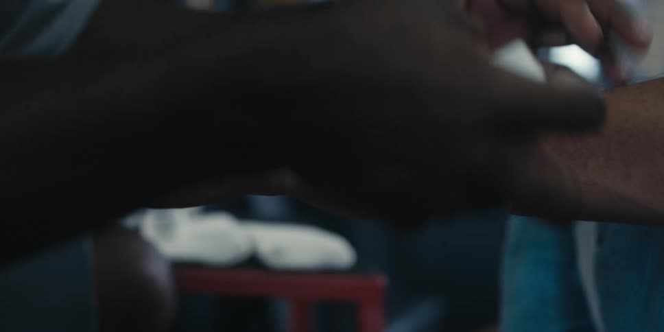 Male trainer wraps the wrist of a man in the gym