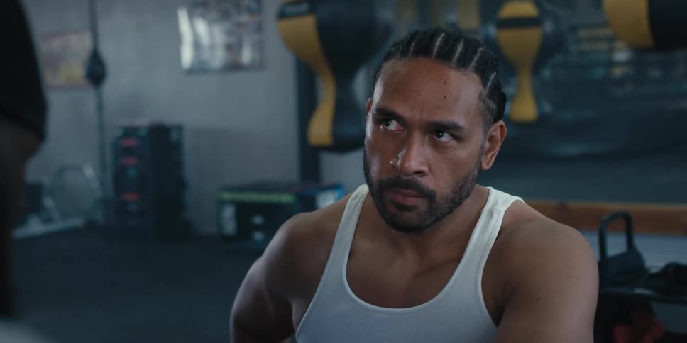 Fighter with serious expression is in a gym environment