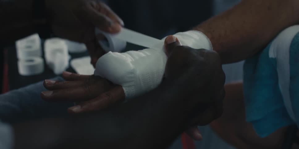 A closeup of a hand being wrapped in a white bandage