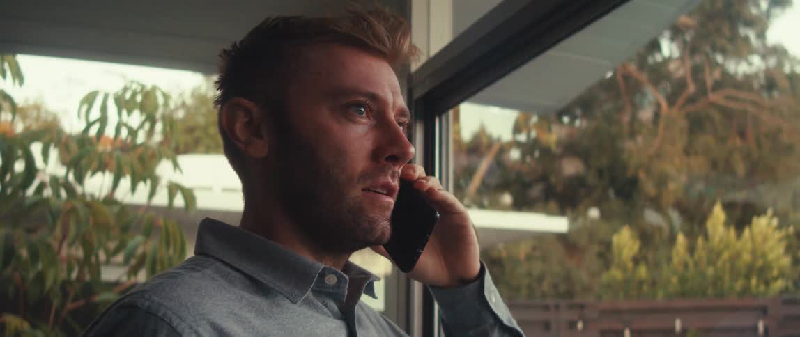 Man in a mirrored environment talking on his cell phone