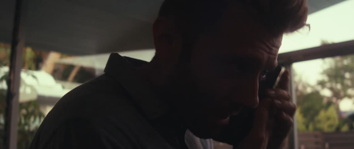 Man standing walking indoors and talking on his cell phone on a call