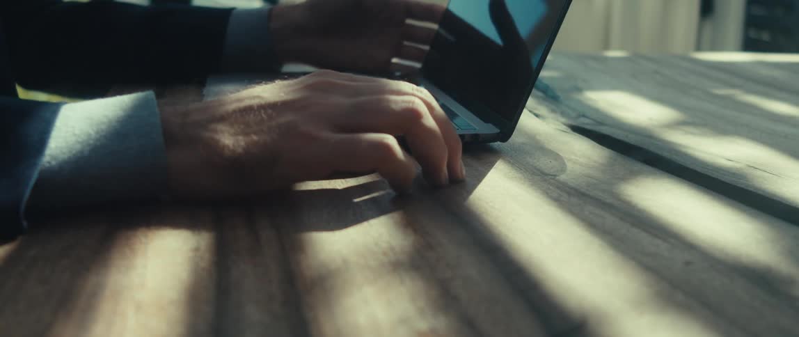 Hands of a man interacting with a laptop