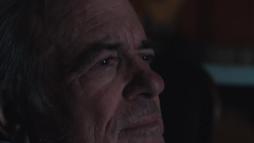 A man smiles as he watches something