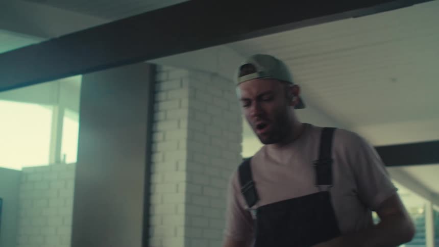 Man singing and dancing while cleaning the house with the vacuum cleaner