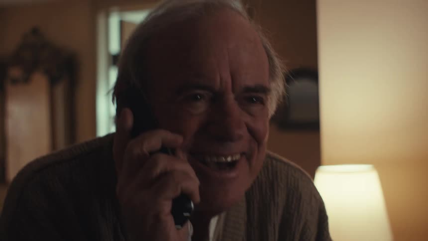 Elderly man laughing and happy while on a phone call