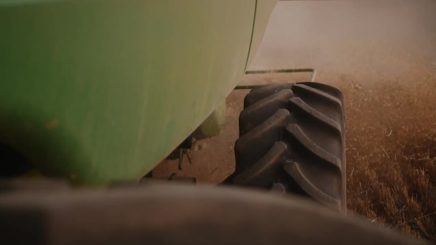 A tractor is working the field on the farm