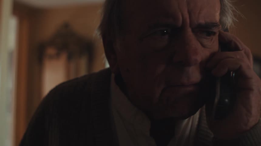 Close up of an elderly man talking on the phone at home