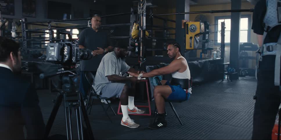 A boxer having his hands taped is being recorded