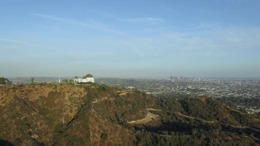 A large domed building sits atop a hill on the outskirts of a city