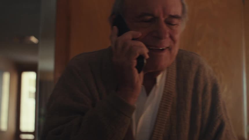 Elderly man talking on cell phone in a cheerful manner