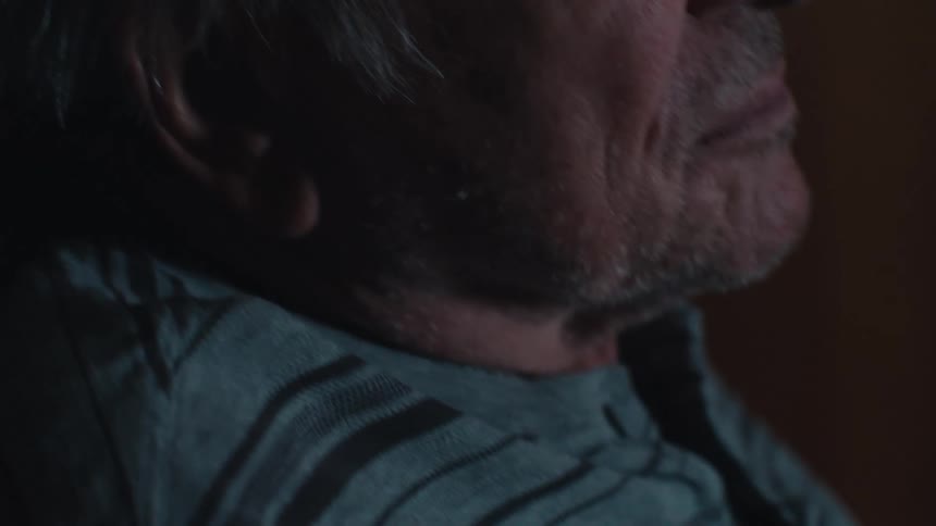 A man uses his remote on the television