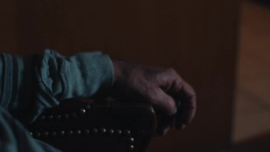Portrait of an elderly man sitting apprehensively watching