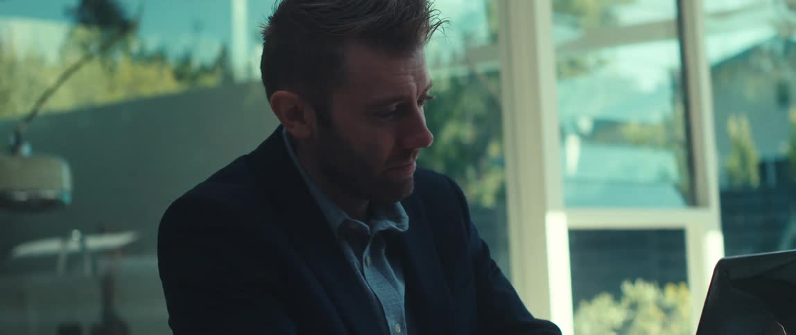 A man is talking with someone on his laptop
