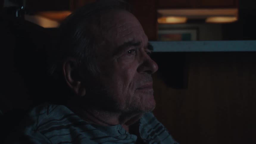 Side view of an elderly man sitting focused watching in a room