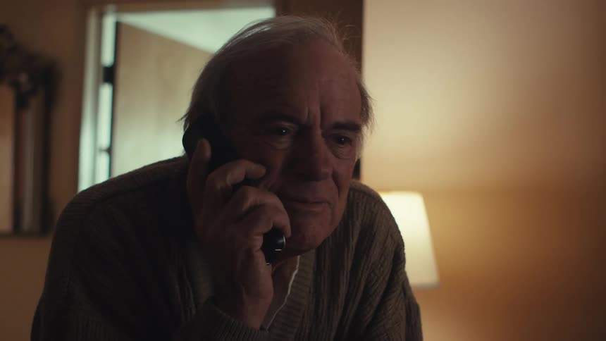 Close up of an elderly man talking on the phone at home