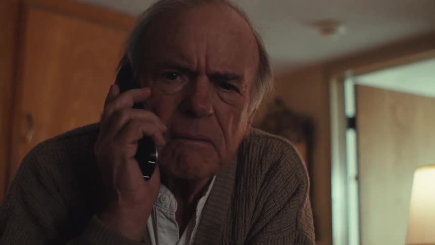 Close up of an elderly man talking on the phone at home