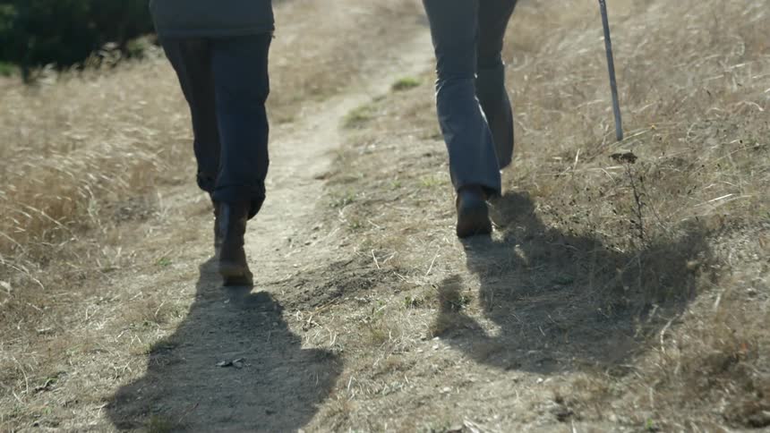 Two people are hiking outdoors on a windy day