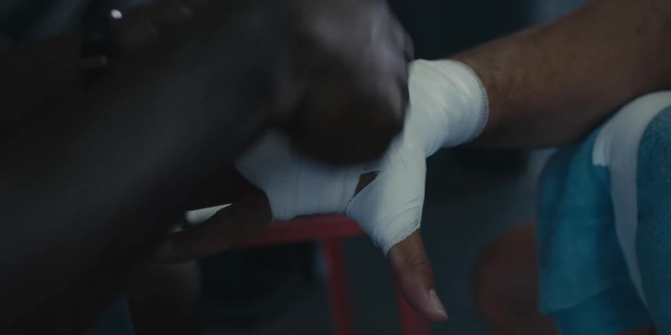 A closeup of a persons hand being wrapped with white athletic tape