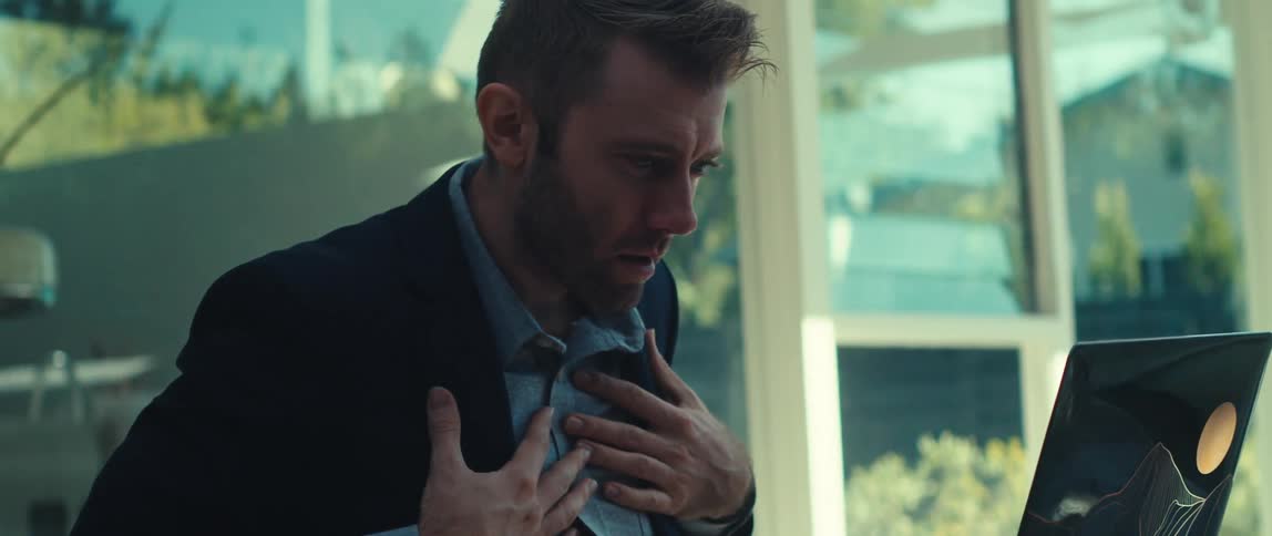 Man getting surprised while in an online meeting on his laptop