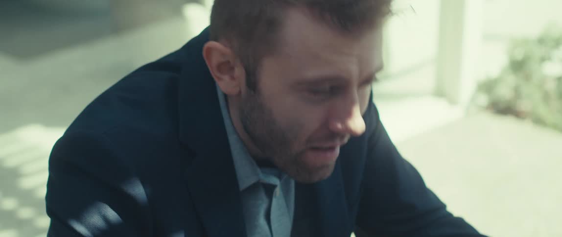 A man is typing on his laptop outside