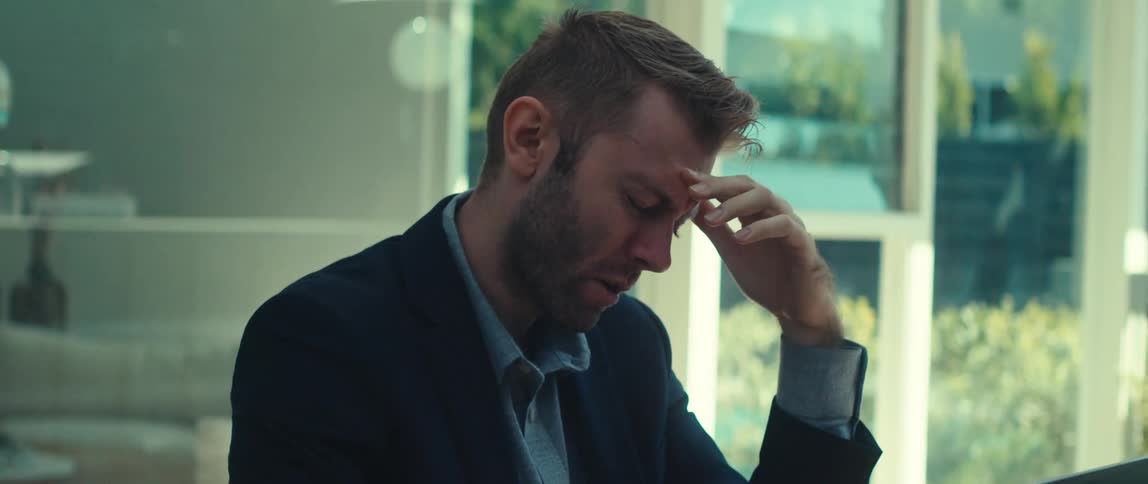 Man in a meeting talking in front of an open laptop