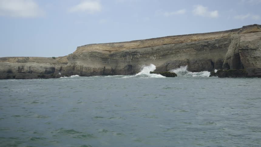 Waves crash against the rocks of the shore