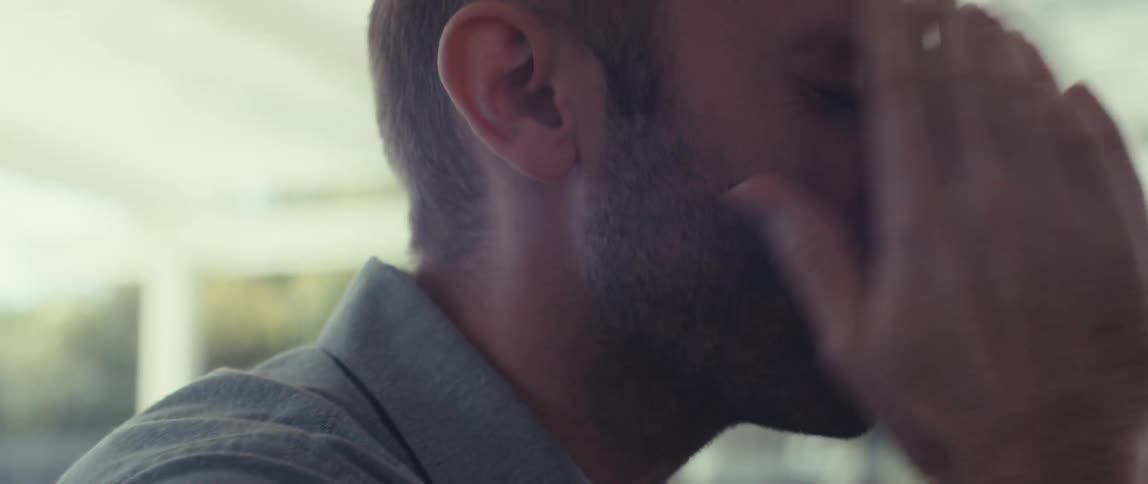 Side view of a man placing his hand on his worried face while talking